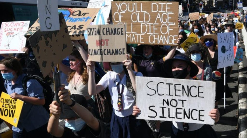Protesters holding up signs at the School Strike 4 Climate rally in Brisbane