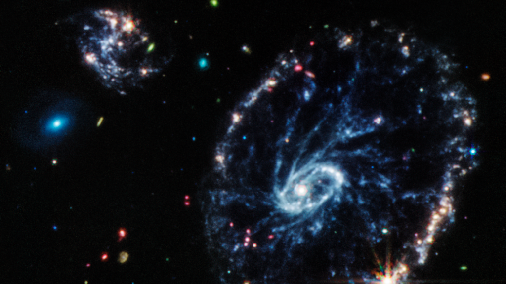 Image from Jame Webb telescope’s Mid-Infrared Instrument (MIRI) shows a group of galaxies, including a large, distorted ring-shaped galaxy, known as the Cartwheel, that is composed of a bright inner ring and an active outer ring.