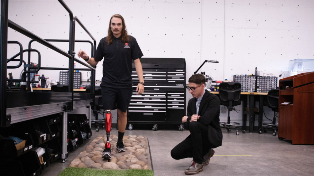 Alec McMorris, an amputee football coach testing the new AI-powered prosthetics on a number of obstacles like rocks and grass at the University of Utah.