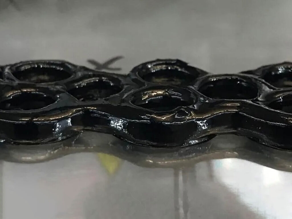 A black metal-like material with holes in it.